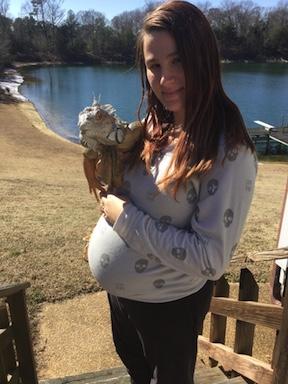 pregnant woman holding iguana